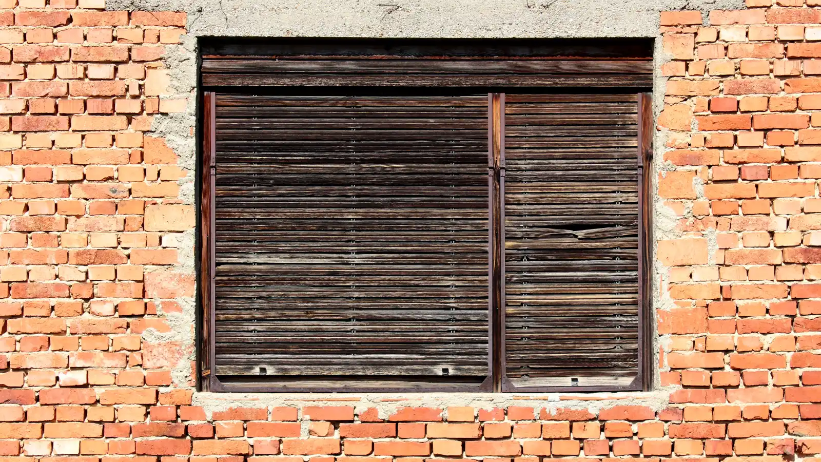 An old window with cracked wooden shutters