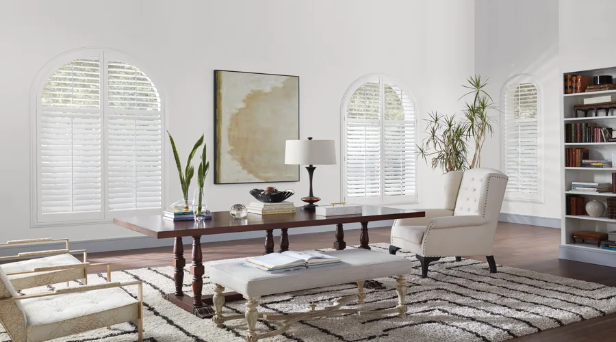 A living room with arched white shutters