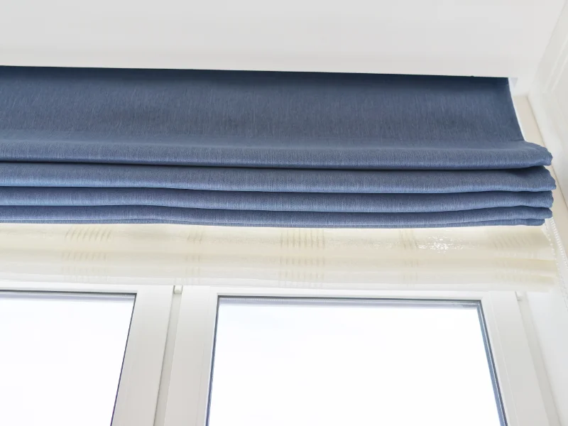 Blue Roman shades fully raised into gentle folds.