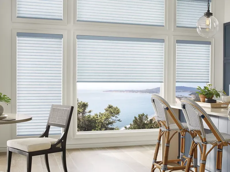 White cellular shades in a kitchen and dining area.